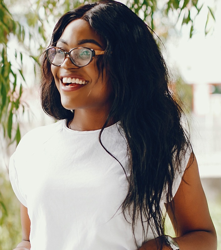 Cute black girl in a park. Lady in a white t-shirt and blue jeans. Woman in a sunglasses